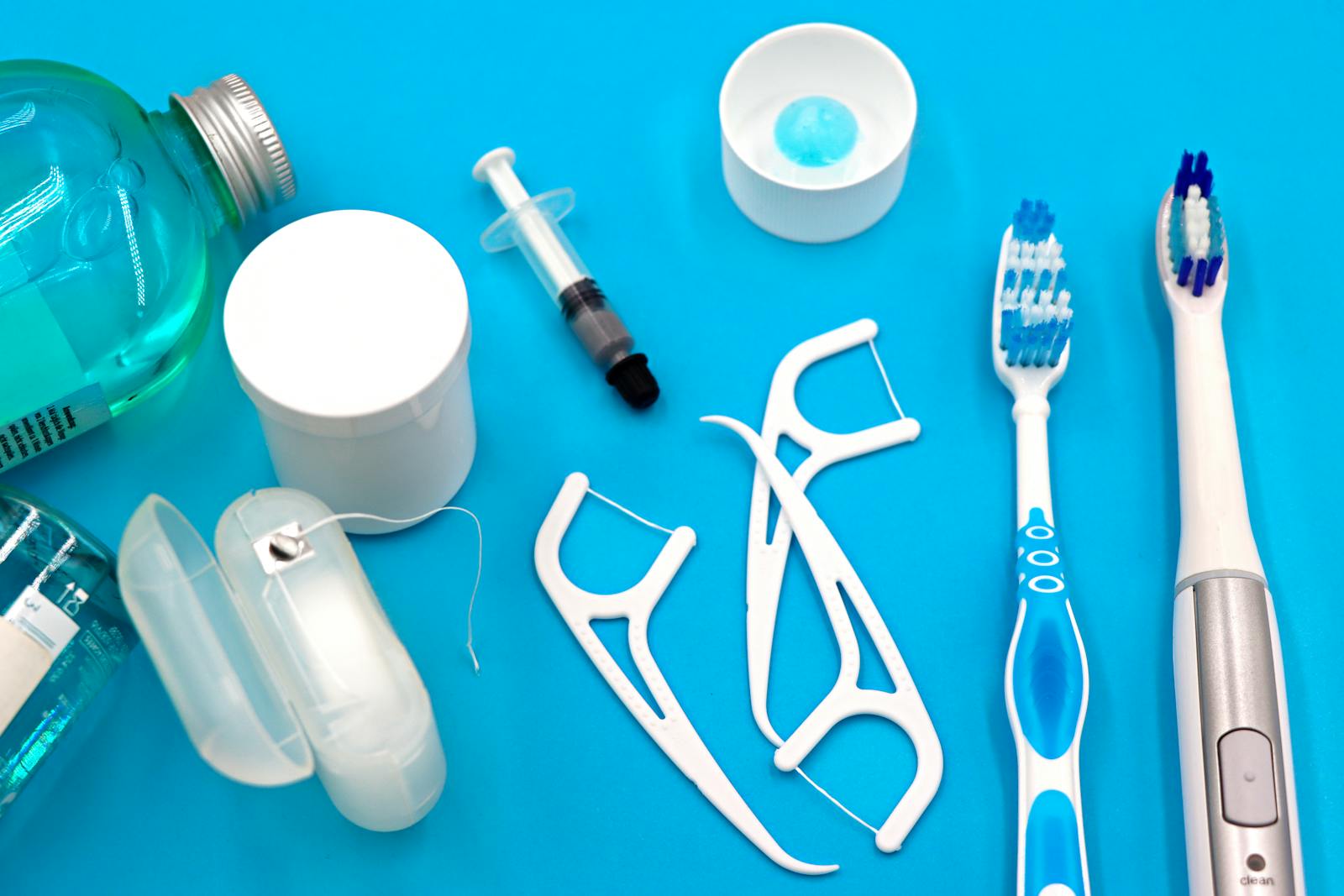 A variety of dental hygiene tools arranged neatly on a vibrant blue surface, showcasing oral care essentials.